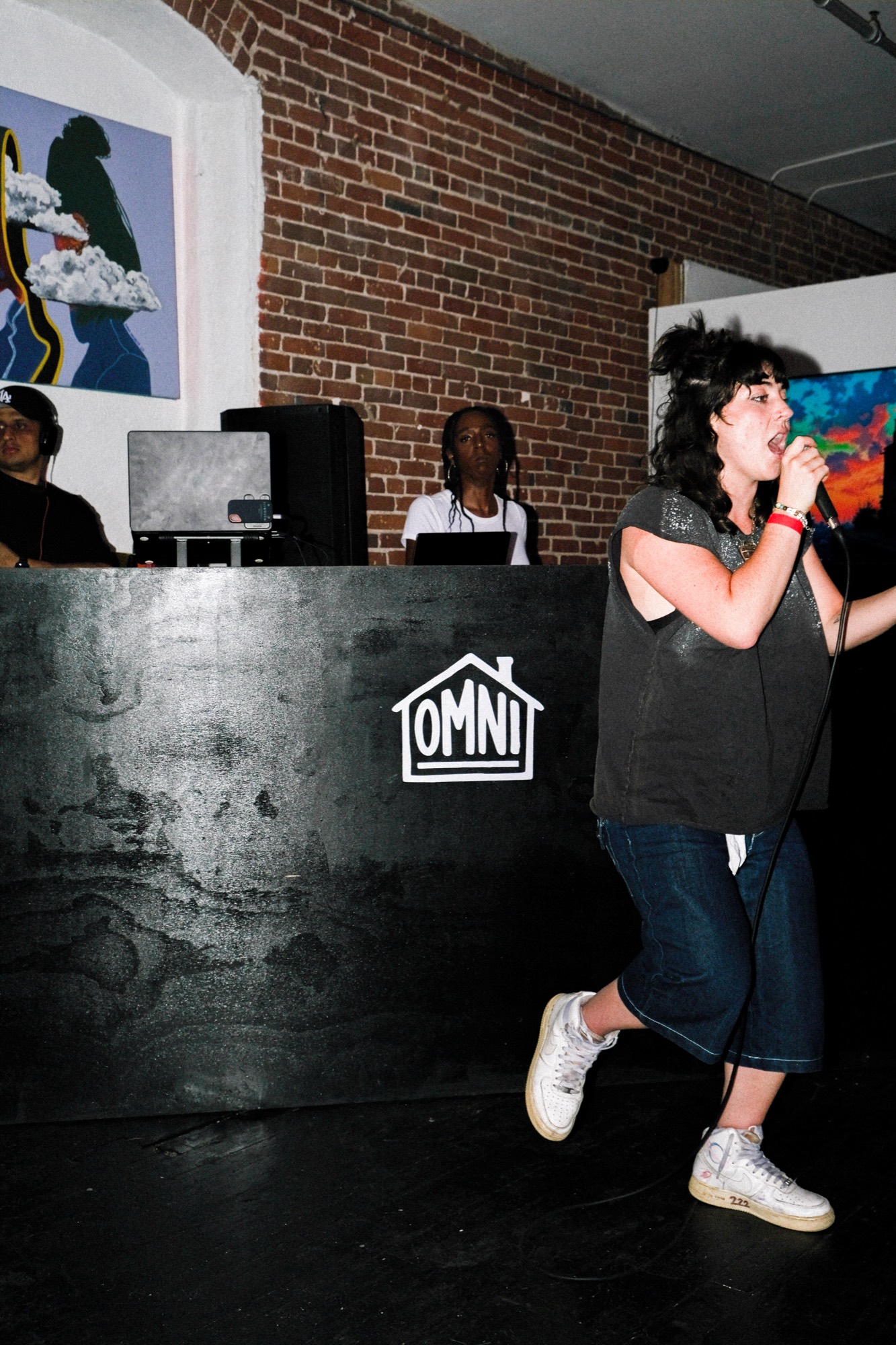 Performer at the mic with the DJ booth